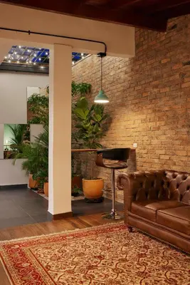 a living room with a couch and a brick wall at El Poblado Medellin Luxury 5BR Jacuzzi AC in Medellín
