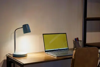a laptop computer sitting on a desk with a lamp at El Poblado Medellin Luxury 5BR Jacuzzi AC in Medellín