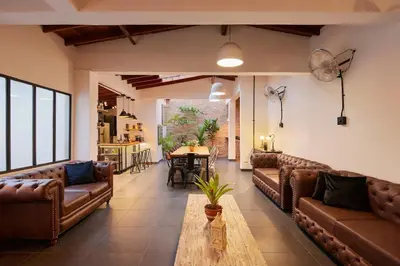 a living room with brown leather couches and a table at El Poblado Medellin Luxury 5BR Jacuzzi AC in Medellín