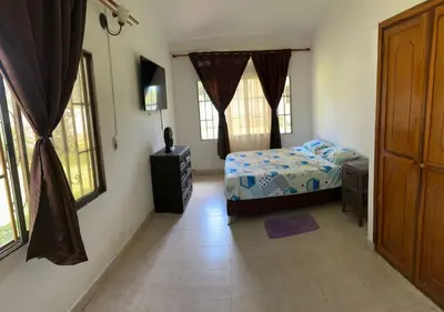 a bedroom with a bed and two windows at villa juliana in Mariquita