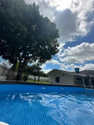 a swimming pool in front of a house with a tree at villa juliana in Mariquita