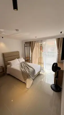 a bedroom with a bed and a large window at Lunaria House - Laureles in Medellín