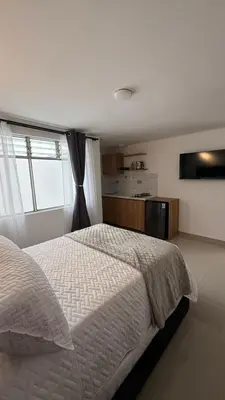 a bedroom with a white bed and a window at Lunaria House - Laureles in Medellín