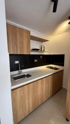 a kitchen with wooden cabinets and a sink at Lunaria House - Laureles in Medellín