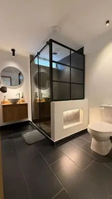 a bathroom with a glass shower and a toilet at Lunaria House - Laureles in Medellín