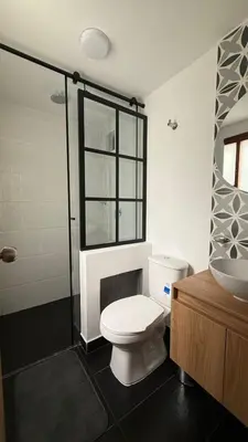 a bathroom with a white toilet and a sink at Lunaria House - Laureles in Medellín