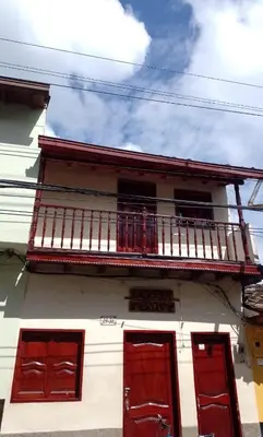 a white building with red doors and a balcony at Aparta estudio en Concepción in Concepción