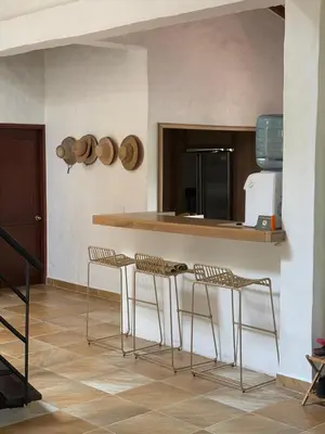 a kitchen with three bar stools and a counter with a counter at Finca La Verbena in San Jerónimo