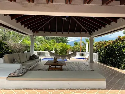 a patio with a couch and a hammock under a pergola at Finca La Verbena in San Jerónimo