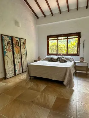 a bedroom with a large bed and a window at Finca La Verbena in San Jerónimo