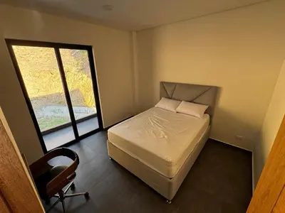 a bedroom with a bed and a chair and a window at Luxury estate in San Jerónimo with infinity pool in San Jerónimo