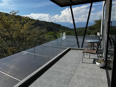 a glass balcony with a table and chairs on it at Luxury estate in San Jerónimo with infinity pool in San Jerónimo