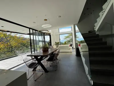a dining room with a table and chairs and a staircase at Luxury estate in San Jerónimo with infinity pool in San Jerónimo