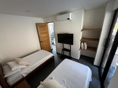 a small room with two beds and a television at Luxury estate in San Jerónimo with infinity pool in San Jerónimo