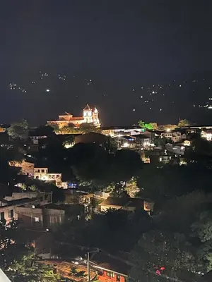 a city at night with a building on a hill at HERMOSO APARTAMENTO CITADELA DI SOLE EN SANTAFE DE ANTIOQUIa in Santa Fe de Antioquia