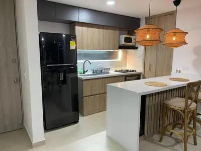 a kitchen with a black refrigerator and a counter at HERMOSO APARTAMENTO CITADELA DI SOLE EN SANTAFE DE ANTIOQUIa in Santa Fe de Antioquia