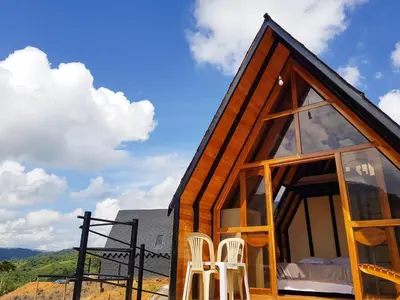 a tiny house with two white chairs and a roof at Ix Cacao in San Carlos