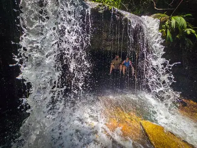 two people sitting in front of a waterfall at Ix Cacao in San Carlos