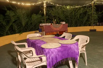 a purple table with white chairs and lights at Eco posada El Encuentro San Carlos frente al rio in San Carlos