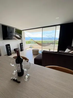 a bottle of wine sitting on a table with glasses at Hermoso Apartamento in Santa Fe de Antioquia