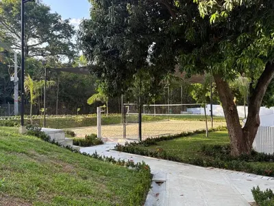 a tennis court in a park with a tree at Hermoso Apartamento in Santa Fe de Antioquia