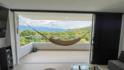 a hammock in a room with a large window at Hermoso Apartamento in Santa Fe de Antioquia