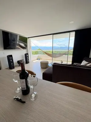 a bottle of wine sitting on a table with glasses at Hermoso Apartamento in Santa Fe de Antioquia