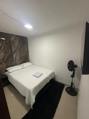 a small bedroom with a bed and a television at Lumière House in Medellín