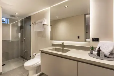 a bathroom with a sink and a toilet and a mirror at Altus Hotel in Medellín