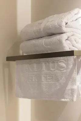 a pile of towels on a shelf in a bathroom at Altus Hotel in Medellín