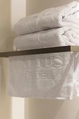 a stack of towels on a shelf with a no us hotel sign at Altus Hotel in Medellín