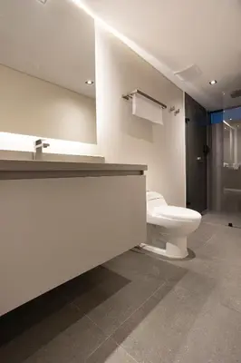 a white bathroom with a toilet and a shower at Altus Hotel in Medellín