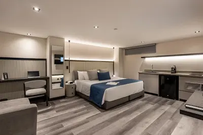 a hotel room with a bed and a desk and a couch at Altus Hotel in Medellín
