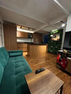 a living room with a green couch and a table at Industrial Chic Apartment Overlooking the City in Medellín