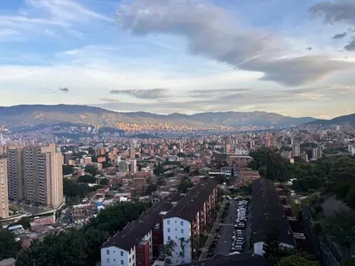 an aerial view of a city with buildings and mountains at Industrial Chic Apartment Overlooking the City in Medellín