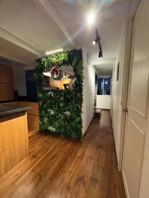 a room with a wall covered in plants at Industrial Chic Apartment Overlooking the City in Medellín