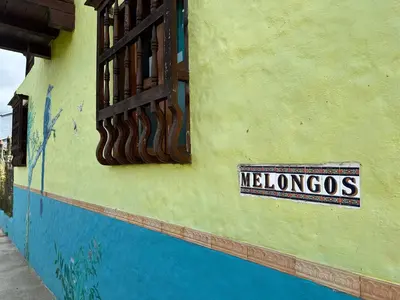 a sign on the side of a building that says mexos at Melongos Jardín in Jardin