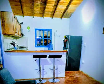 a kitchen with a counter and a refrigerator and stools at Lactesano es Vida in La Unión