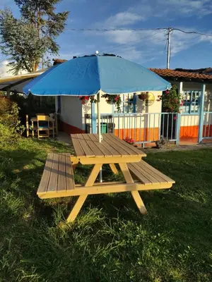 a picnic table with an umbrella in the grass at Lactesano es Vida in La Unión