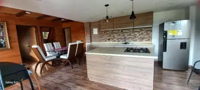 a kitchen with a refrigerator and a table with chairs at Chalet MA in Guatapé