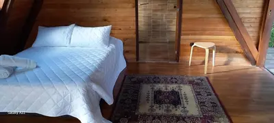 a bedroom with a bed and a stool in a room at Chalet MA in Guatapé