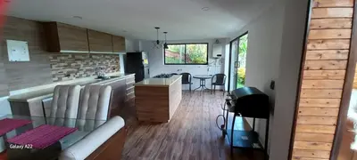 a kitchen and a living room with a glass table at Chalet MA in Guatapé