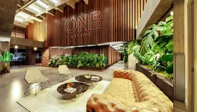 a lobby with a couch and tables and plants at Envigado Luxury Stay - Apartment in City Plaza in Envigado