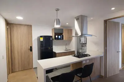 a kitchen with a white counter and a black refrigerator at Envigado Luxury Stay - Apartment in City Plaza in Envigado
