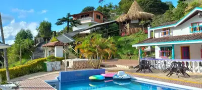 a house with a swimming pool in front of a house at Casa de Campo MA in Chiquinquirá