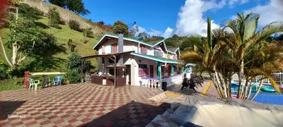 a house on a hill next to a swimming pool at Casa de Campo MA in Chiquinquirá