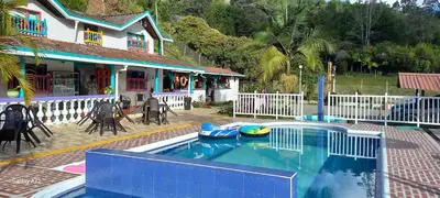a house with a swimming pool in front of a house at Casa de Campo MA in Chiquinquirá