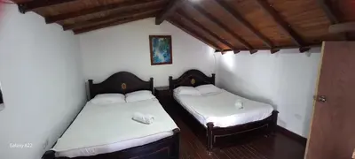 two beds in a room with white sheets at Casa de Campo MA in Chiquinquirá