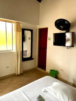 a bedroom with a bed and a tv on the wall at Hotel Restaurante La Costica Dulce in San Carlos