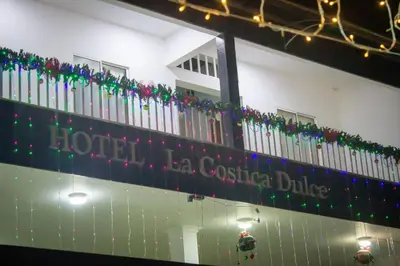 a building with christmas lights and a sign on it at Hotel Restaurante La Costica Dulce in San Carlos
